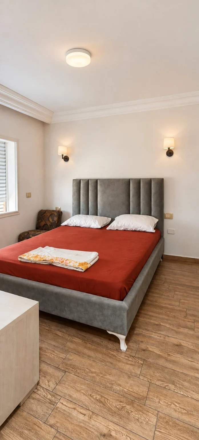 Chambre avec un lit double et une tête de lit grise