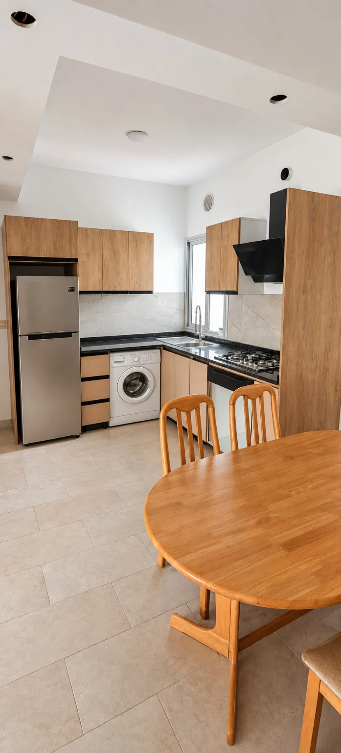 Cuisine avec réfrigérateur, lave-linge et table à manger